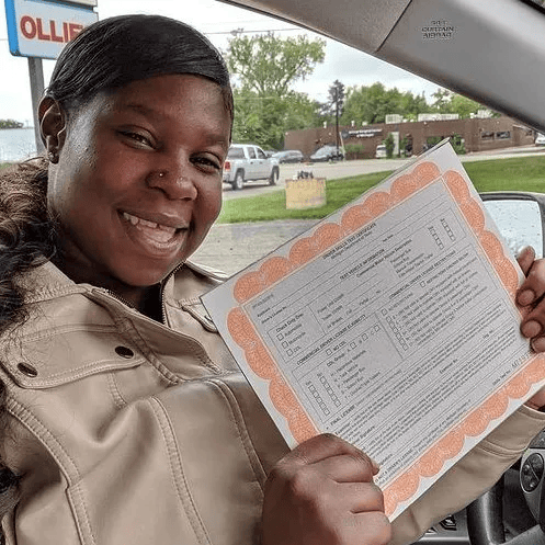 A teenage girl inside car showing certificate